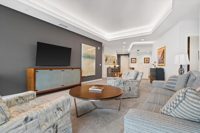 living room featuring carpet floors, visible vents, a raised ceiling, and recessed lighting