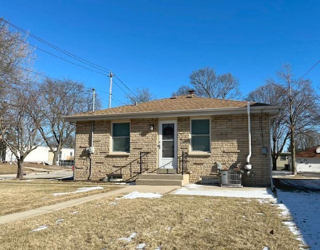 view of front facade featuring central AC unit and brick siding