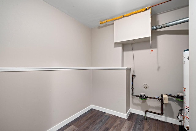 laundry area featuring laundry area, dark wood-type flooring, gas water heater, and baseboards