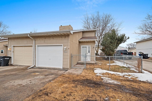 view of front of property featuring a chimney, an attached garage, and fence