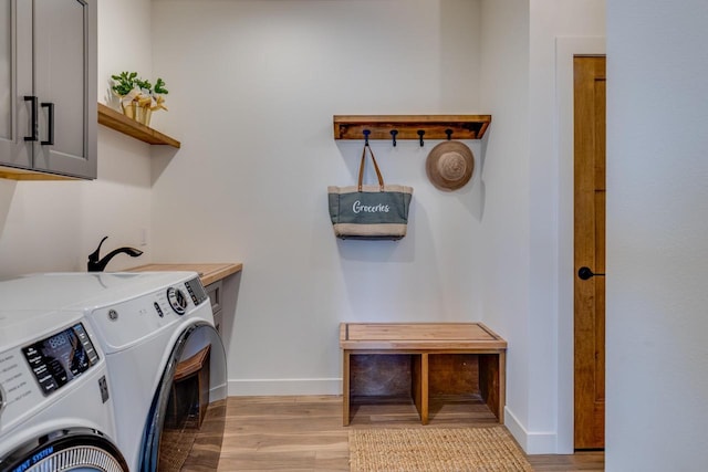 laundry room with separate washer and dryer, wood finished floors, cabinet space, and baseboards