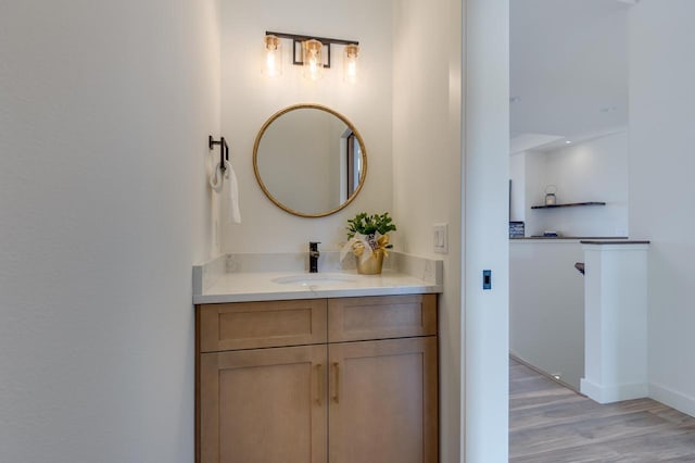 bathroom featuring vanity, baseboards, and wood finished floors