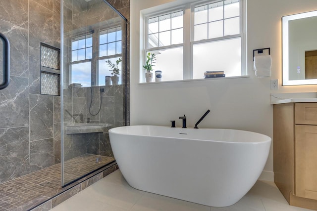 bathroom featuring a stall shower, tile patterned flooring, vanity, and a soaking tub