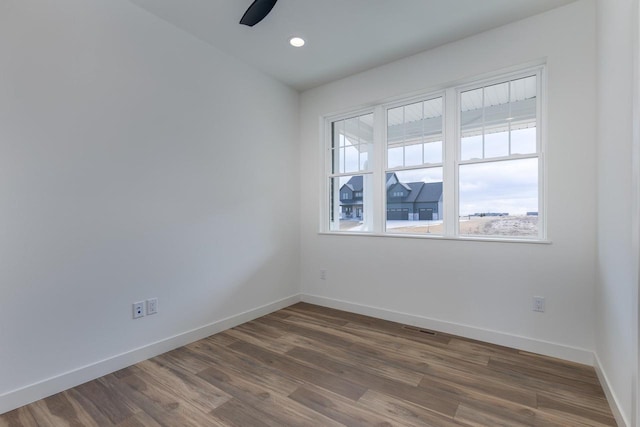 empty room with dark wood-style floors, recessed lighting, ceiling fan, and baseboards