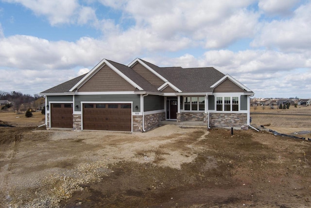 craftsman inspired home with stone siding, driveway, and an attached garage