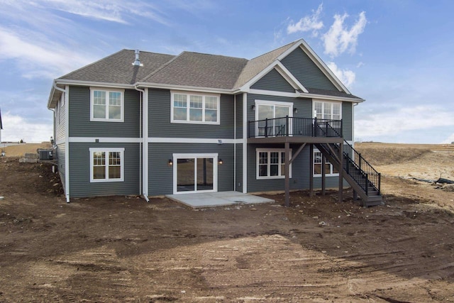 rear view of house with central air condition unit, roof with shingles, stairway, and a patio