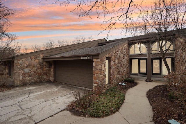 mid-century home featuring stone siding and roof with shingles