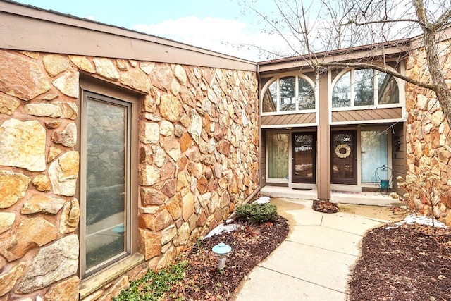 property entrance featuring stone siding