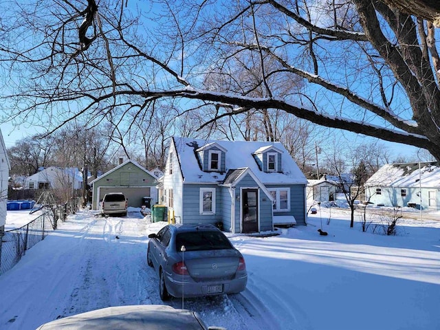 view of front of house with a detached garage, fence, and an outdoor structure