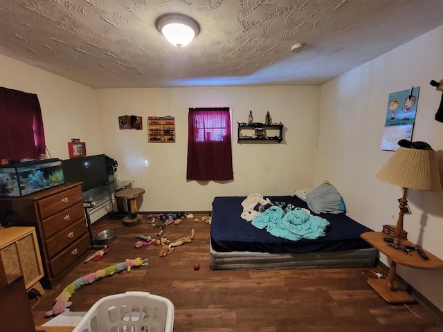 bedroom with a textured ceiling and wood finished floors