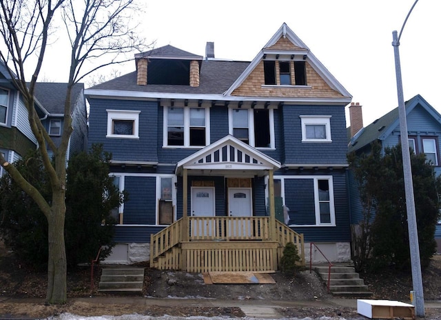 view of front of house featuring a shingled roof and a chimney