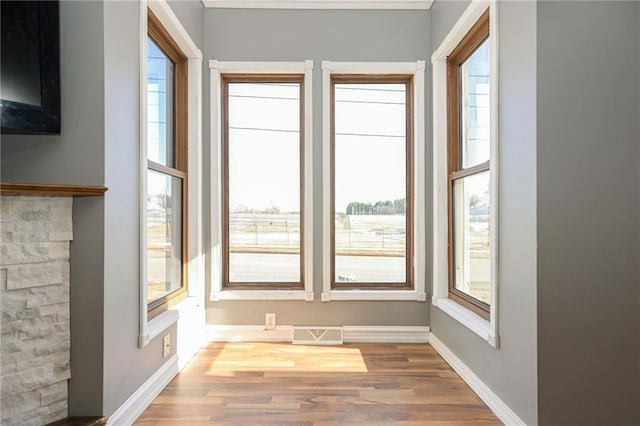 doorway with visible vents, baseboards, and wood finished floors