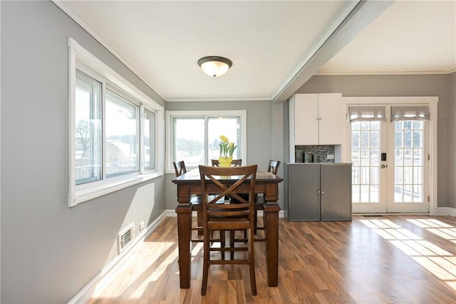 dining room featuring baseboards, visible vents, wood finished floors, and french doors