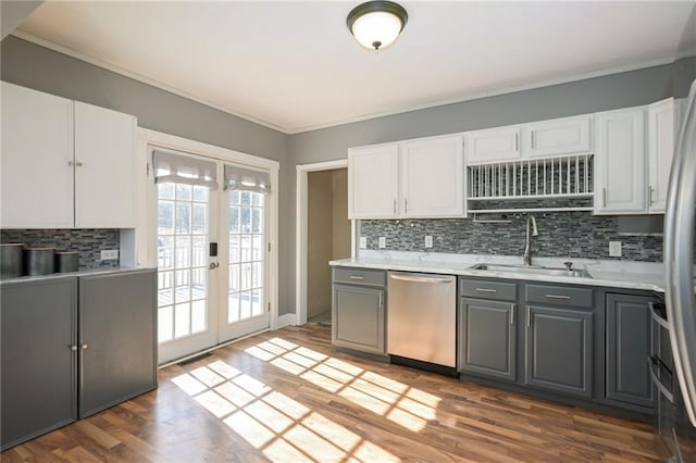 kitchen with gray cabinetry, appliances with stainless steel finishes, light countertops, french doors, and a sink