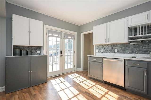 kitchen featuring backsplash, gray cabinets, french doors, stainless steel dishwasher, and a sink