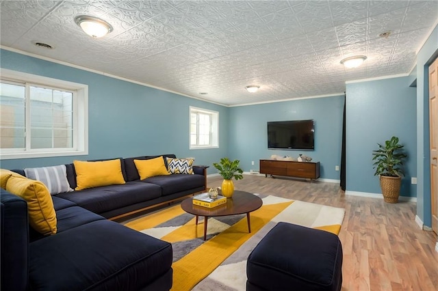 living room featuring visible vents, crown molding, baseboards, and wood finished floors