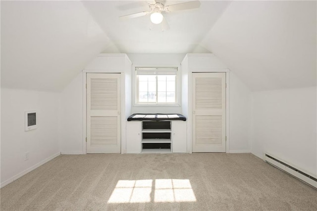 additional living space with lofted ceiling, visible vents, baseboard heating, carpet flooring, and ceiling fan