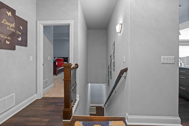 staircase featuring visible vents, baseboards, and wood finished floors