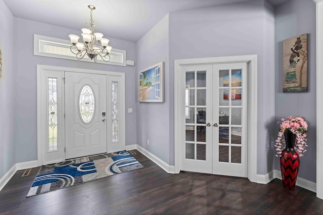 entrance foyer featuring french doors, baseboards, a notable chandelier, and wood finished floors