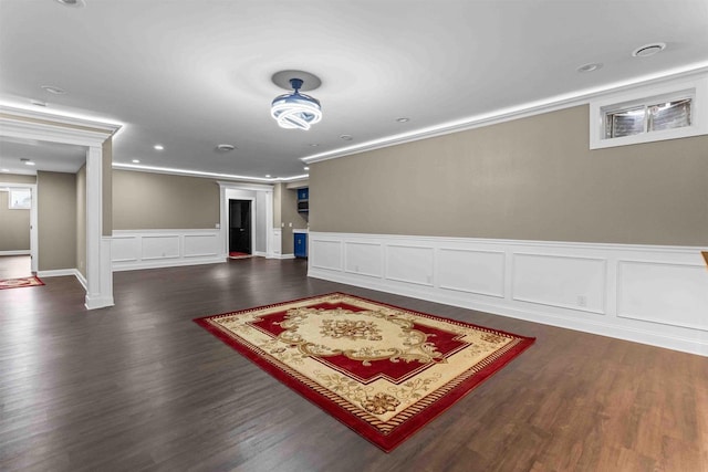 finished below grade area featuring dark wood-style floors and ornamental molding