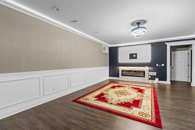 living room with visible vents, wood finished floors, a fireplace, and crown molding