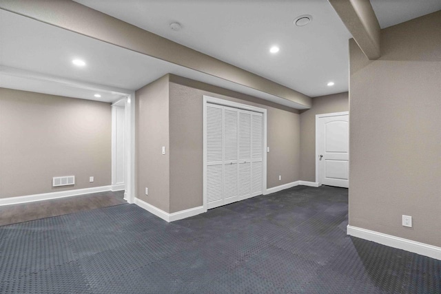 basement featuring visible vents, recessed lighting, baseboards, and dark colored carpet