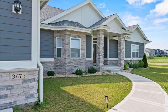 view of front of property featuring stone siding, board and batten siding, a shingled roof, and a front lawn