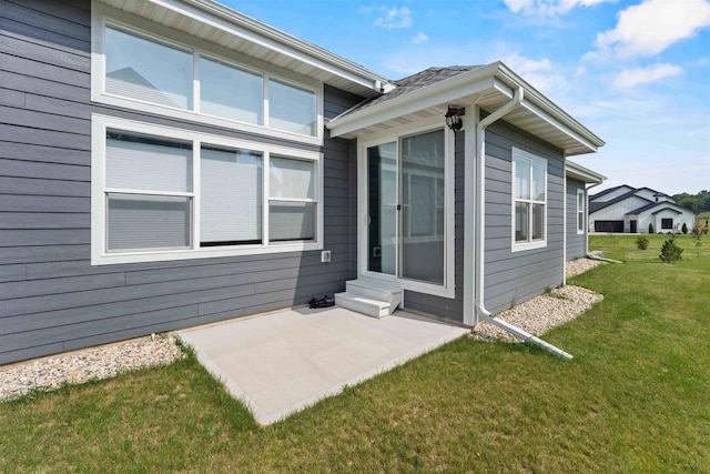 doorway to property with a yard and a patio