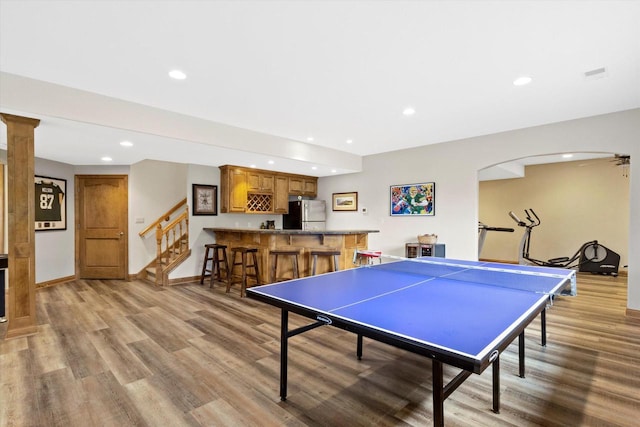 rec room with light wood-type flooring, wet bar, baseboards, and recessed lighting