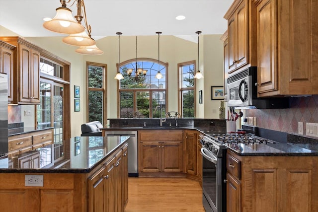 kitchen with appliances with stainless steel finishes, brown cabinetry, and a sink