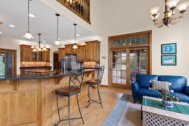 kitchen featuring a kitchen bar, brown cabinetry, french doors, and freestanding refrigerator