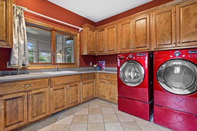 laundry room featuring light tile patterned flooring, cabinet space, a sink, and separate washer and dryer