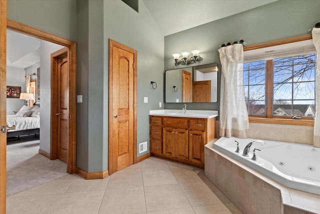 ensuite bathroom with tile patterned flooring, vaulted ceiling, vanity, and a tub with jets