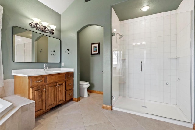 bathroom with toilet, a shower stall, vanity, tile patterned flooring, and baseboards