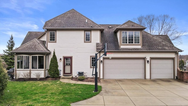 view of front of home featuring a shingled roof, a front yard, and concrete driveway