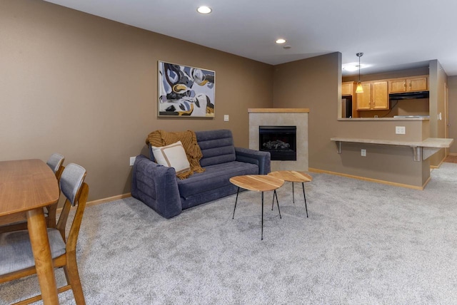 carpeted living room with a fireplace, baseboards, and recessed lighting