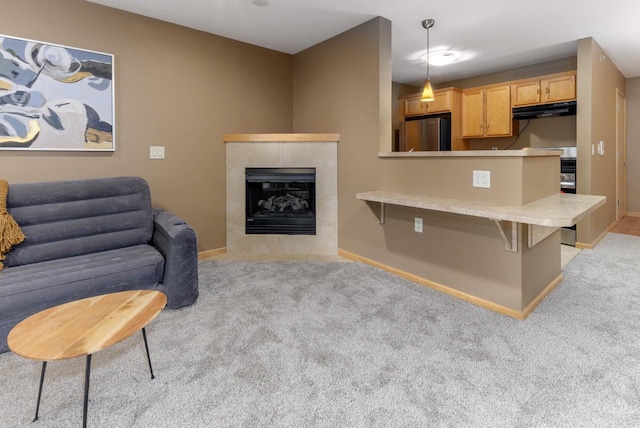 living room featuring light carpet, a fireplace, and baseboards