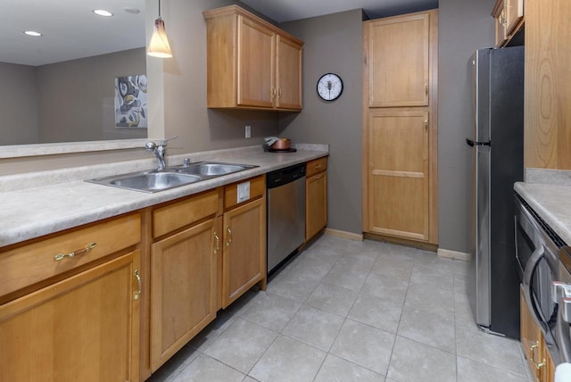 kitchen featuring light tile patterned floors, stainless steel appliances, light countertops, a sink, and baseboards