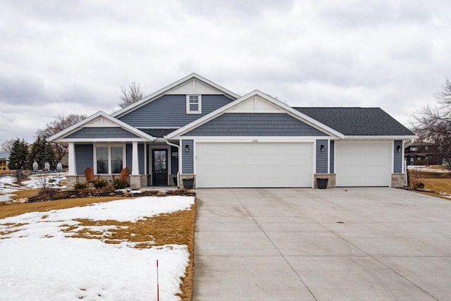 craftsman house with stone siding, driveway, and an attached garage