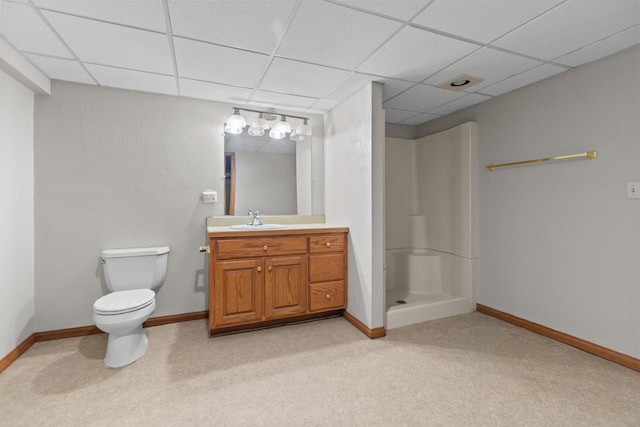 full bath with a paneled ceiling, toilet, a stall shower, vanity, and baseboards