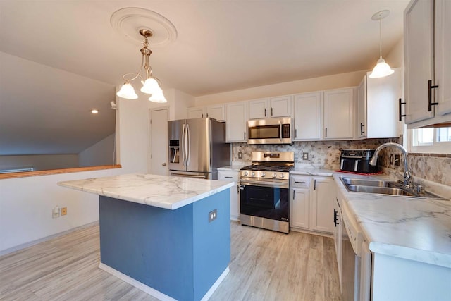 kitchen with tasteful backsplash, a kitchen island, stainless steel appliances, and a sink