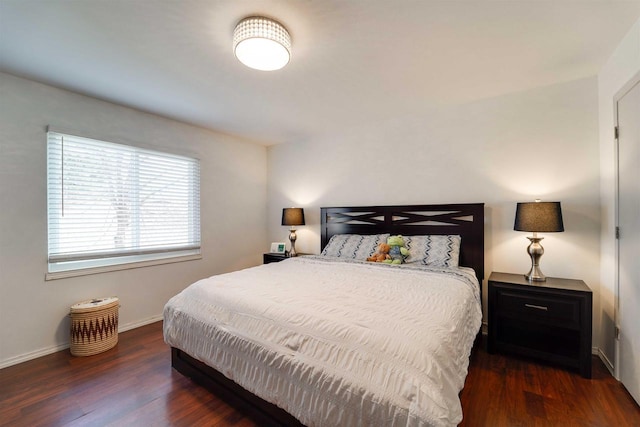 bedroom with wood finished floors and baseboards