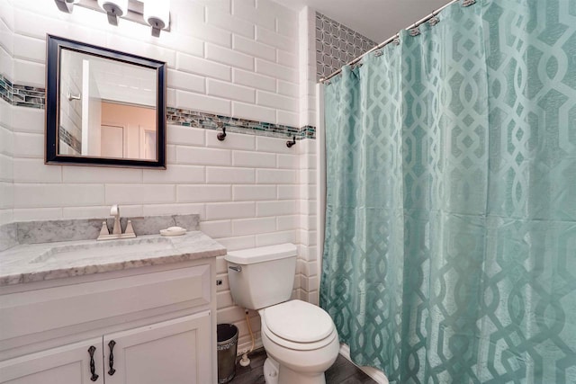 bathroom featuring tile walls, curtained shower, vanity, and toilet