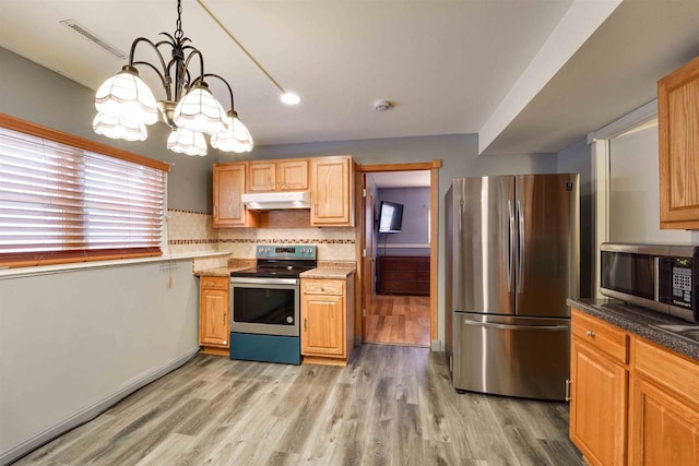 kitchen with stainless steel appliances, light wood-type flooring, visible vents, and under cabinet range hood