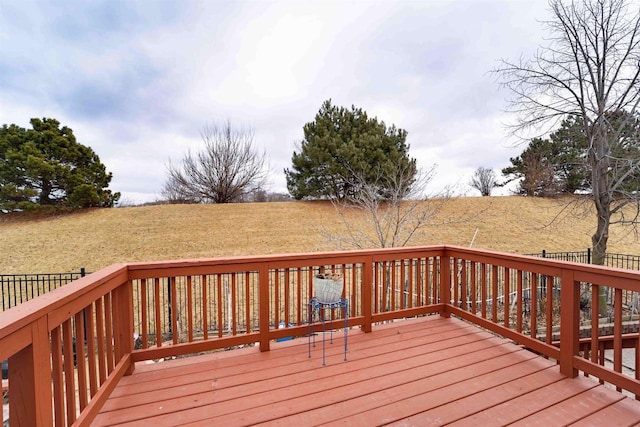 wooden terrace featuring a rural view and a yard