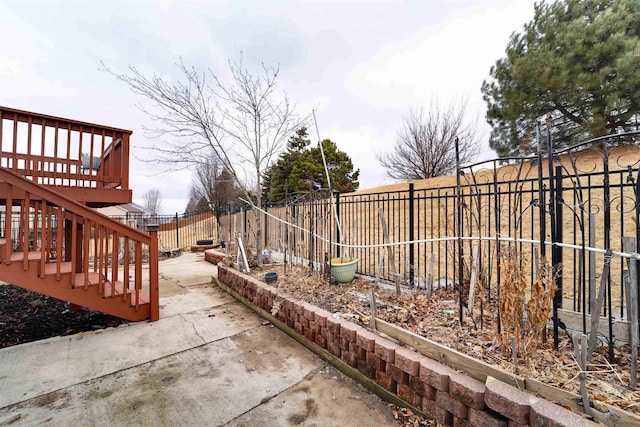 view of patio with a deck, a fenced backyard, and stairway