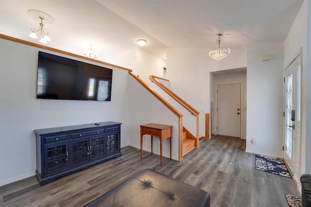 entrance foyer with wood finished floors, stairway, and an inviting chandelier