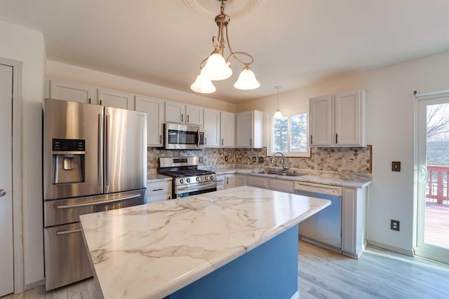 kitchen featuring a kitchen island, a sink, appliances with stainless steel finishes, backsplash, and pendant lighting