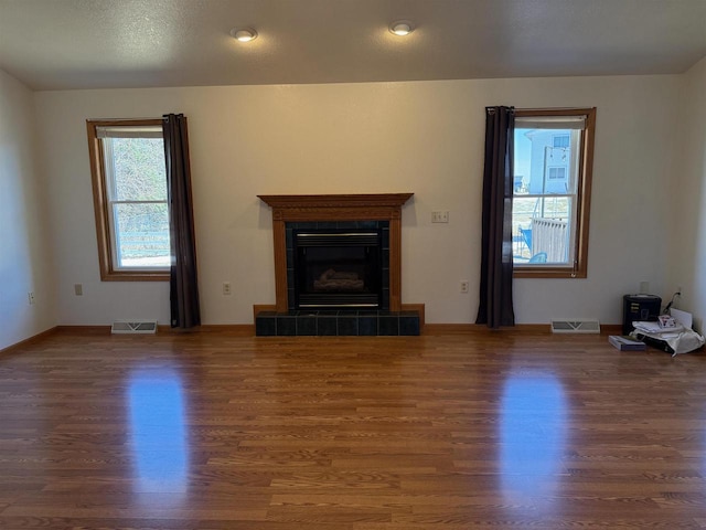 1080 Jaystone Ter, Waterloo, WI 53594 - unfurnished living room featuring a fireplace, visible vents, and wood finished floors