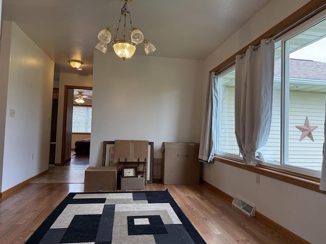 1080 Jaystone Ter, Waterloo, WI 53594 - unfurnished dining area featuring wood finished floors, baseboards, a chandelier, and a ceiling fan
